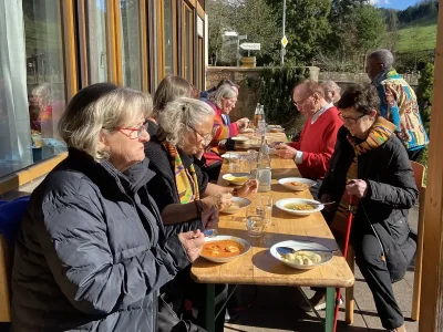Teilnehmende des Gottesdienstes beim gemeinsamen Essen und Austausch im Freien.