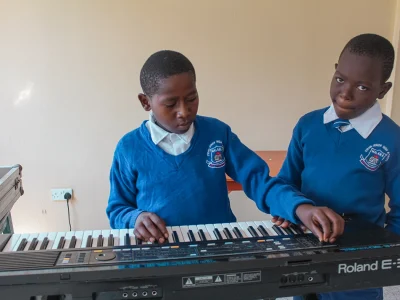 Zwei Jungs testen das Keyboard im Musikzimmer