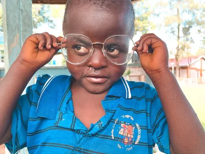 Ein kleiner Junge probiert Milenas Brille an.