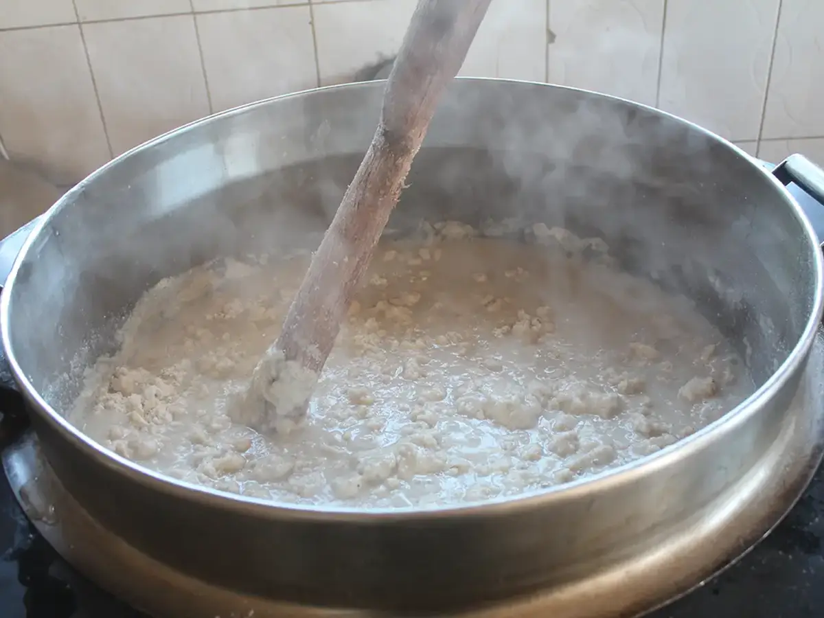 Frisch zubereitetes Ugali wird in einem großen Kochtopf in der Malaika-Küche gerührt.