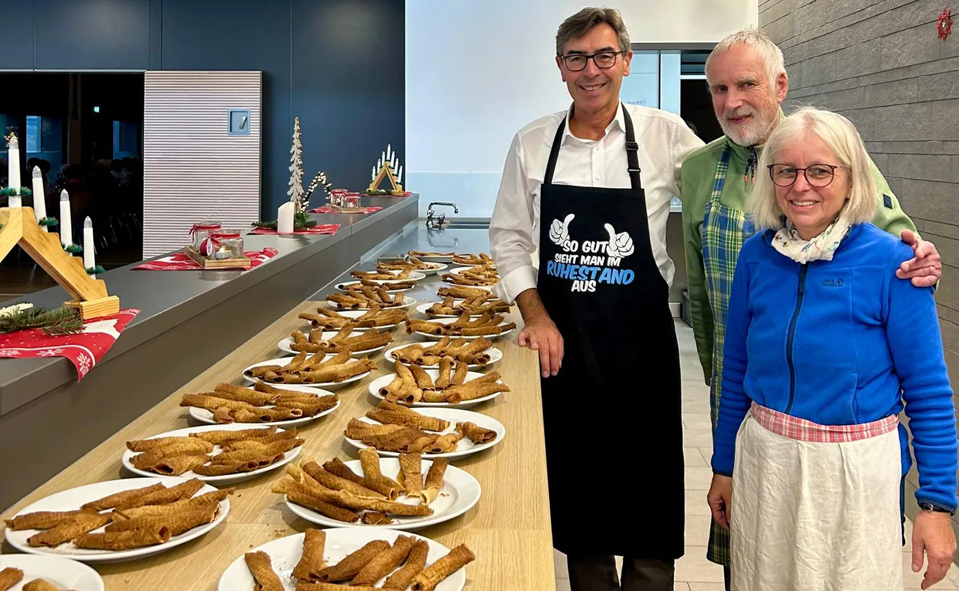 Angelika und Wolfgang Kleeb sowie Bernd Siefermann stehen vor gebackenen Zimtwaffeln an der Theke, die sie zugunsten von Malaika am Seniorennachmittag in Renchen gemacht haben.