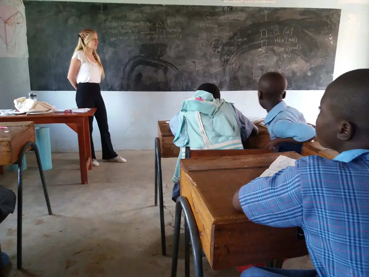 Amelie Herlan steht vorne an der Tafel und unterrichtet die Kinder in Deutsch.