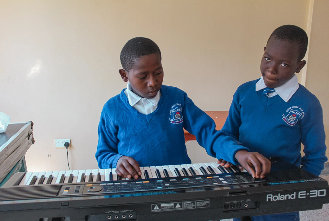 Zwei Jungs testen das Keyboard im Musikzimmer