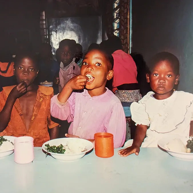Waisenheimkinder sitzen am Tisch und essen Ugali.